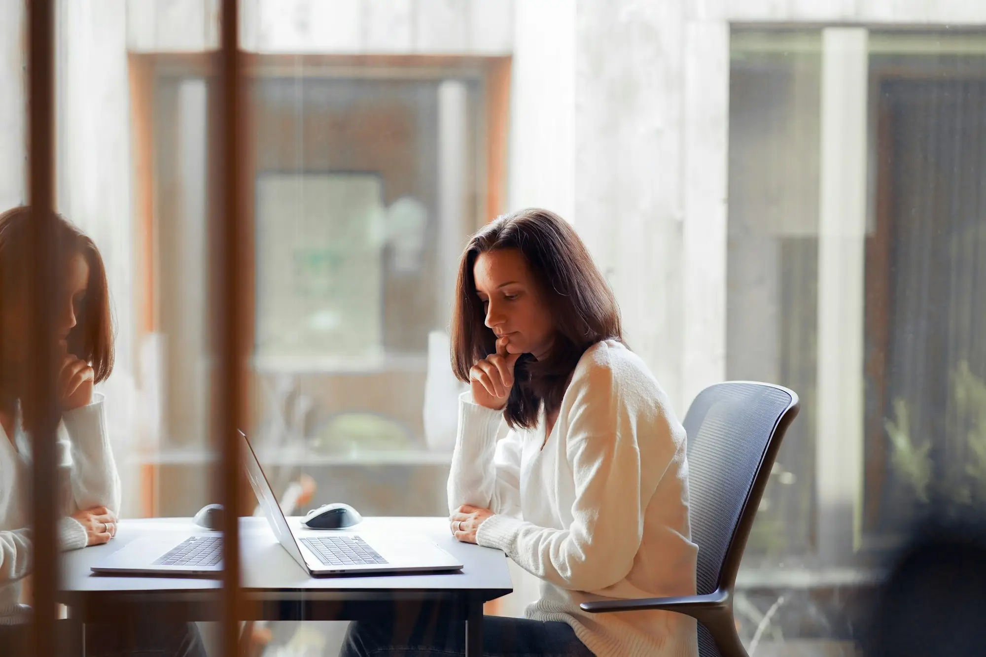 Woman working calmly at her office desk with her phone set aside